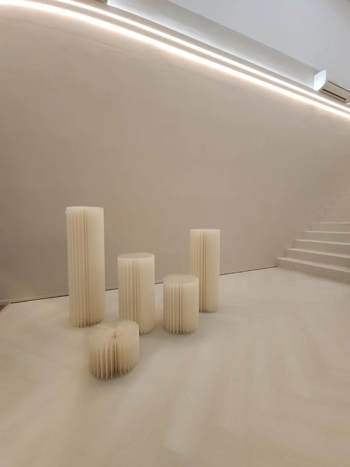 Fluted cream plinths arranged by the staircase