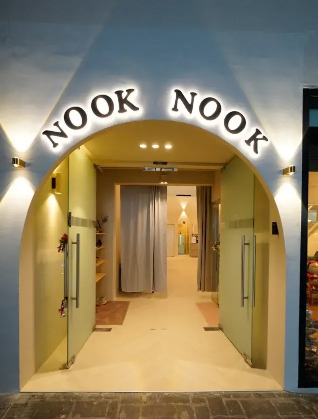 The arched Nook Nook entrance, lit and decorated with flowers