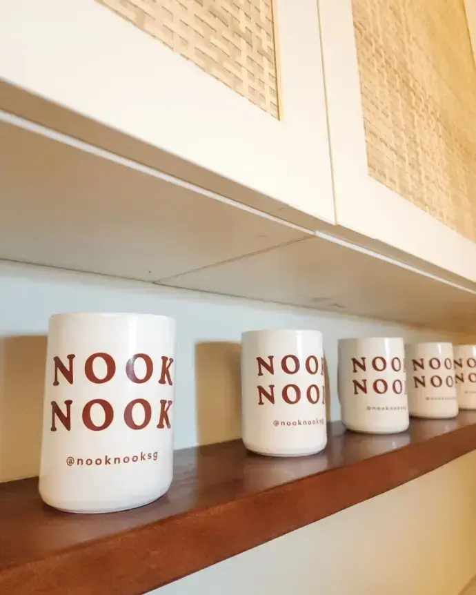 Nook Nook mugs lined along the shelf