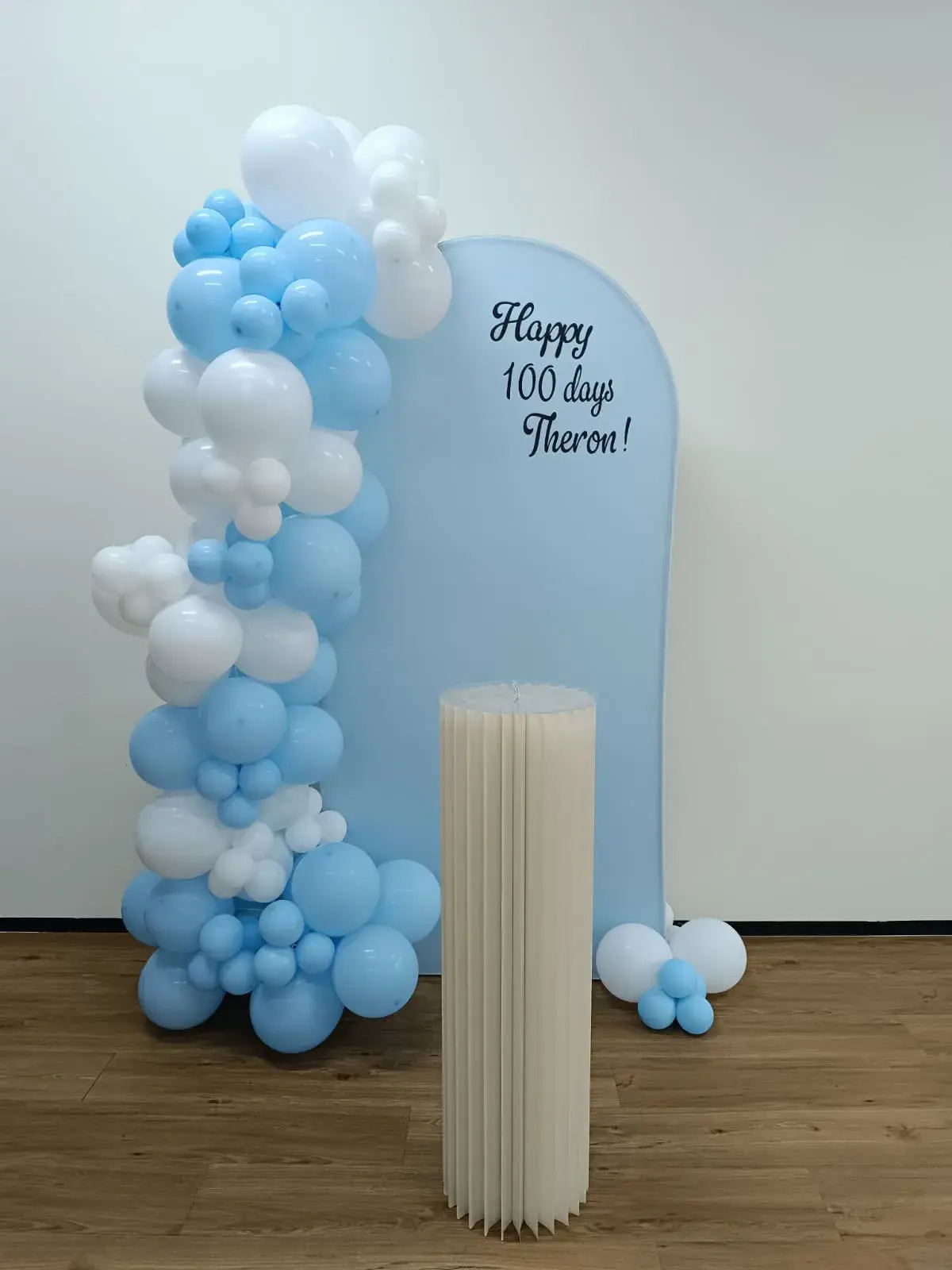 A pale blue balloon arch set up for a hundred day celebration