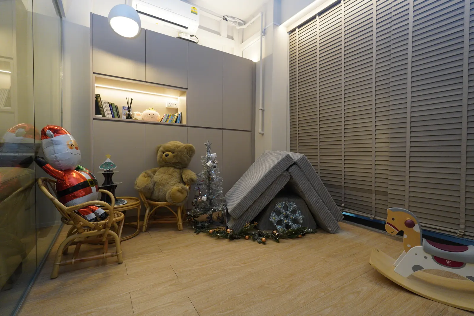 The playroom with rattan chairs, a teddy, a rocking horse and a small Christmas tree